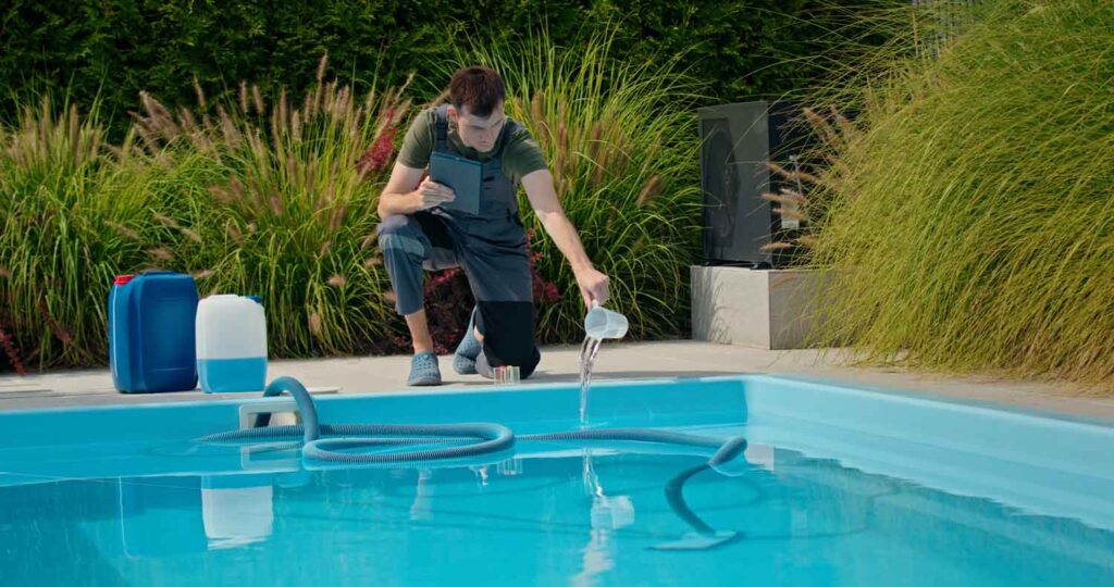 Hombre joven y profesional, mide el cloro de una piscina.